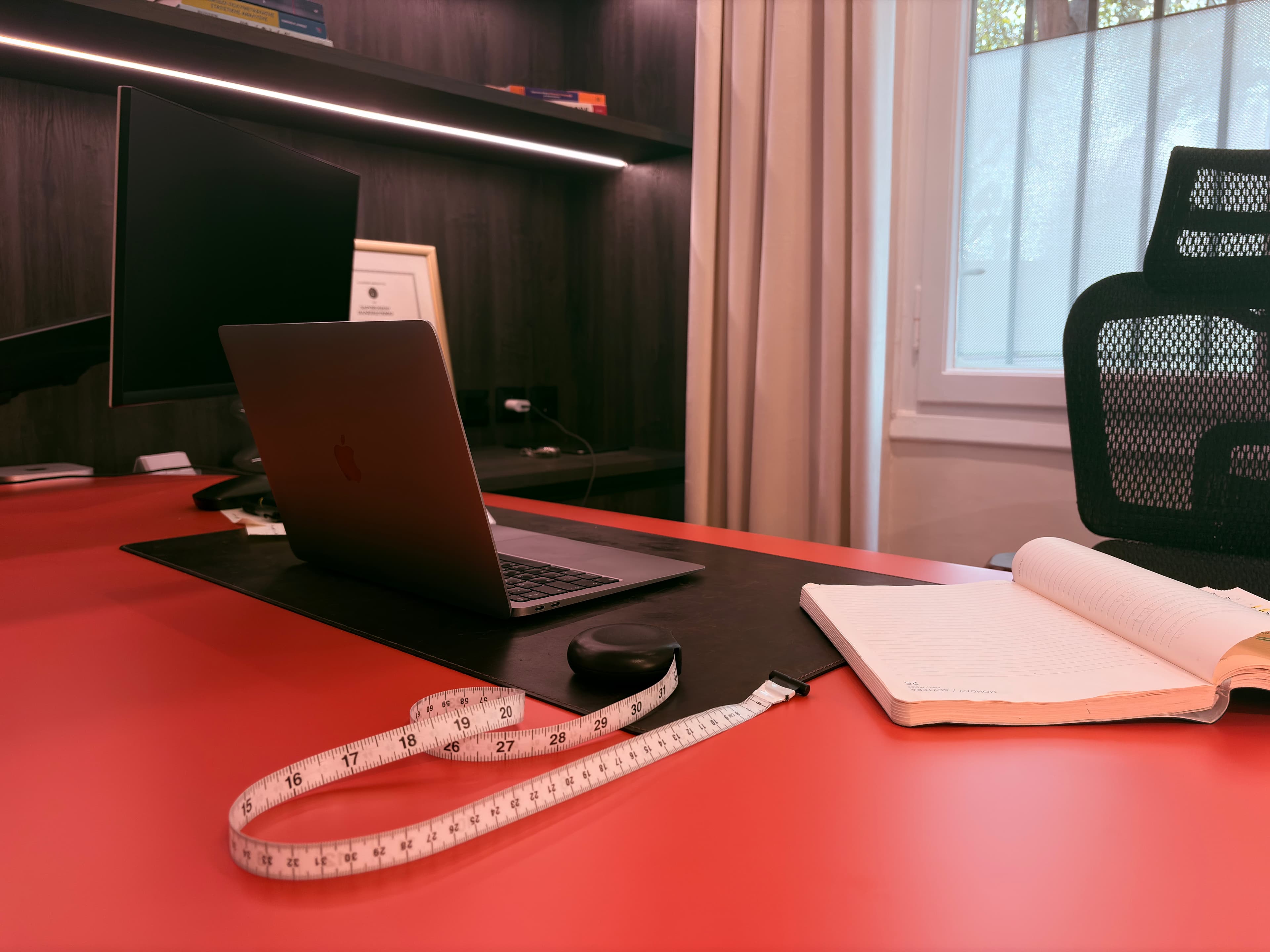 Nutrition consultation equipment, measuring tape, notes, and a tablet on a warm office desk.